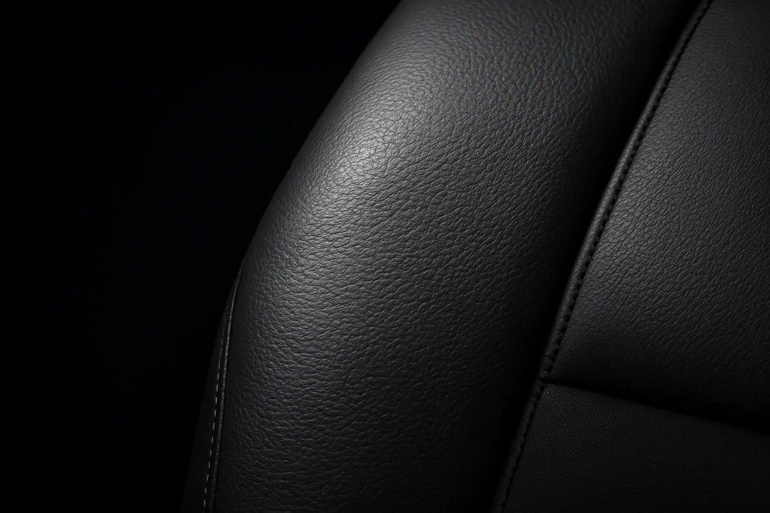 Interior detailing service — conditioned leather seat in studio lighting